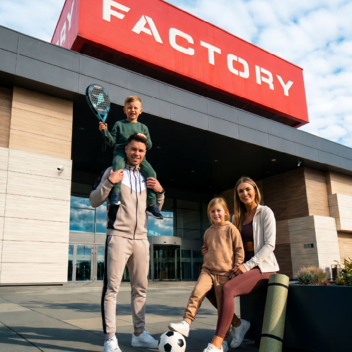 rodzina z budynkiem Factory w tle