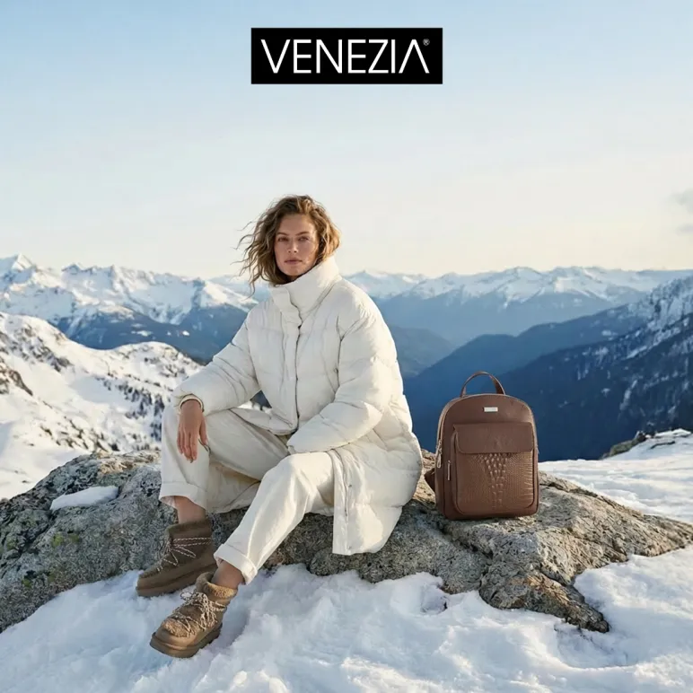 kobieta w białej kurtce siedzi na szczycie góry